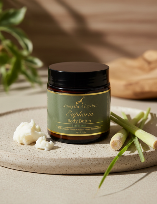 amber glass Jar of Jamylla alathia Euphoria whipped Body Butter on a textured surface with lemongrass , shea butter and leaves.