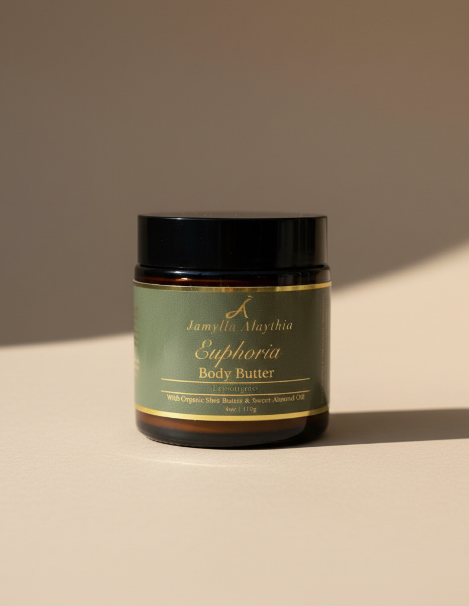 Jar of Euphoria Body Butter with a green and gold label on a beige background and soft shadows